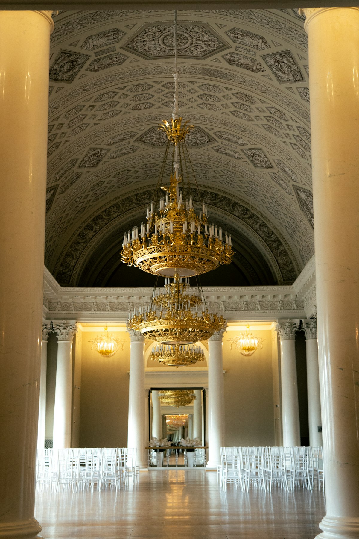 Grand luxury wedding venue ballroom with crystal chandeliers and dramatic lighting